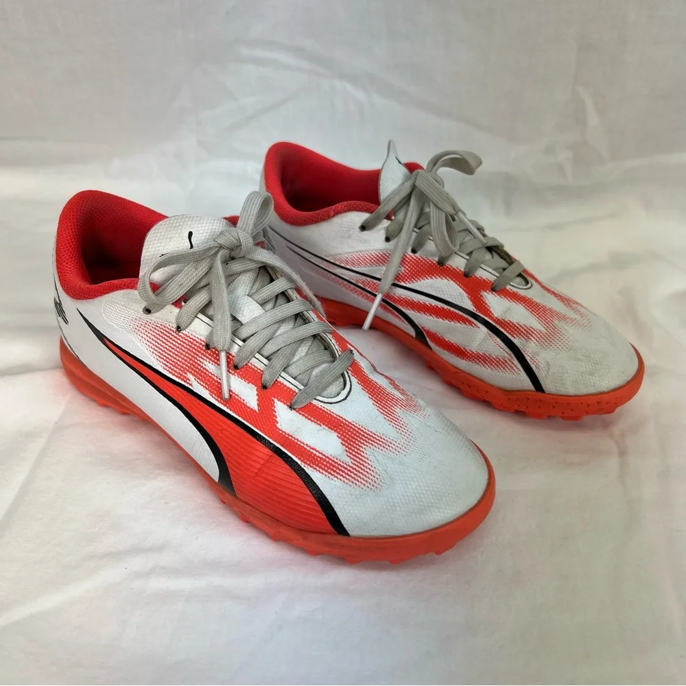 Puma kids turf shoes in white, bright coral and black.